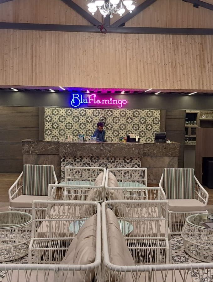Rooftop lounge featuring illuminated Blu Flamingo logo with ambient lighting at BluSalzz Residence, Amritsar